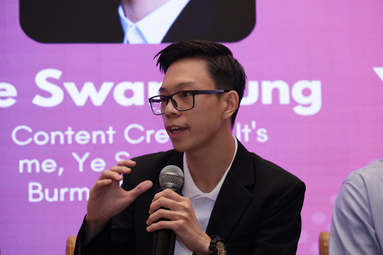 Ye Swan Aung speaking into a microphone during the Pixels of Identity panel in Mumbai
