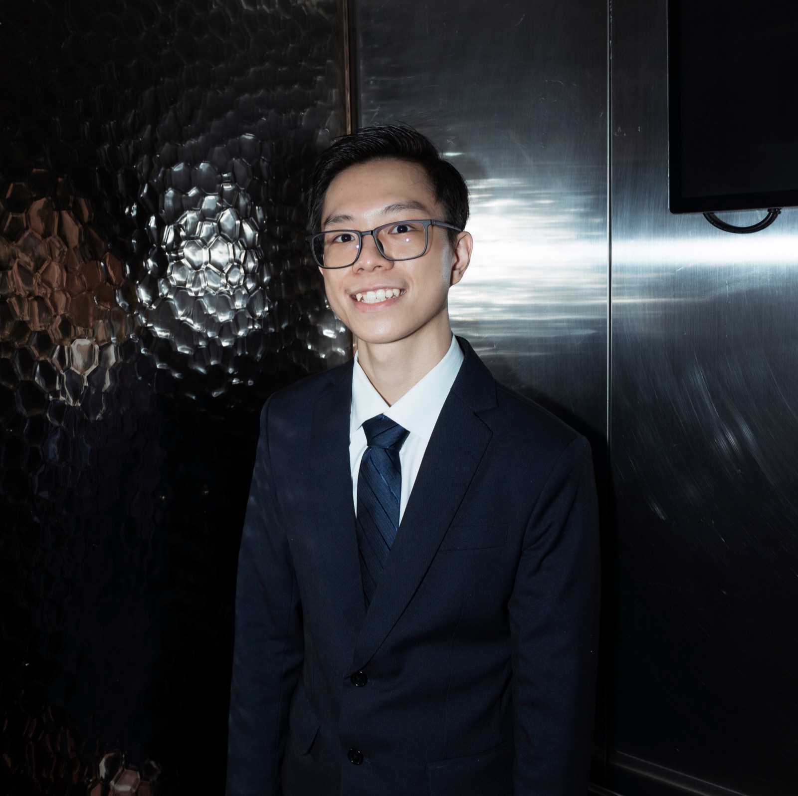 Ye Swan Aung smiling in a dark suit and tie